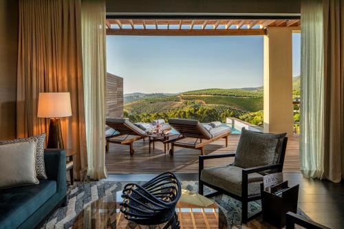 un soggiorno con divano, sedie e una grande finestra di Delaire Graff Lodges and Spa a Stellenbosch