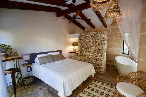 een slaapkamer met een bed en een badkamer met een bad bij La Casa Menorca in Ferreries