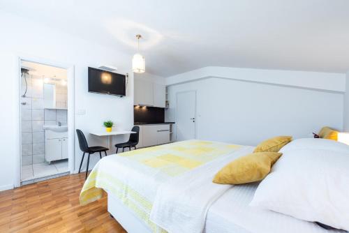 a white bedroom with a bed and a bathroom at Villa Mimoza in Cavtat