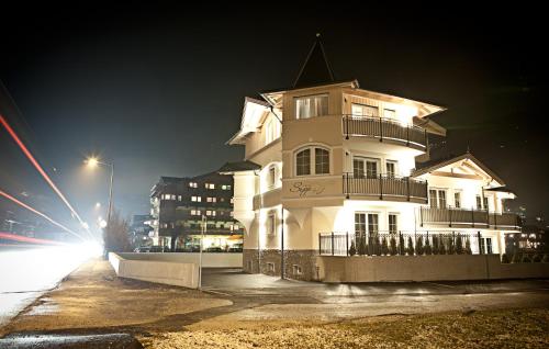 a tall white building at night with a street light at Villa Sepp in Ramsau im Zillertal