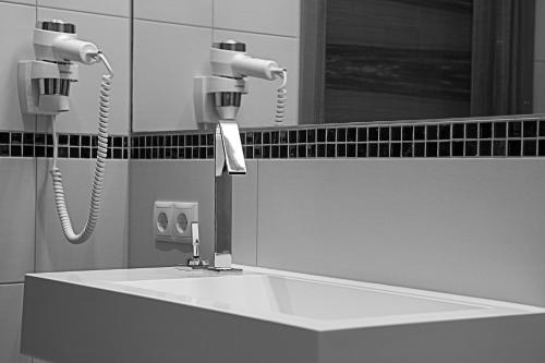 a bathroom sink with two blow dryers and a mirror at Villa Sepp in Ramsau im Zillertal