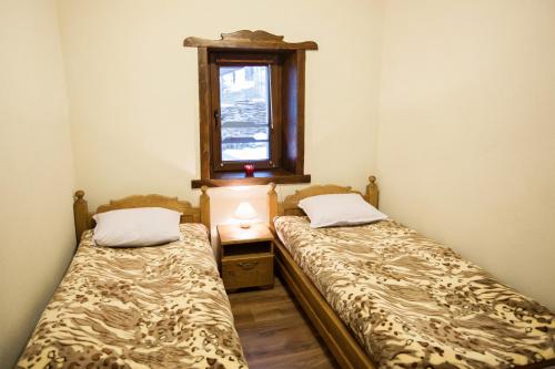 two beds in a small room with a window at Guest House Panorama in Gela