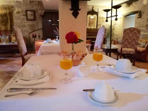 einen Tisch mit einem weißen Tischtuch und zwei Gläsern Orangensaft in der Unterkunft Château de Fourcès in Fourcès