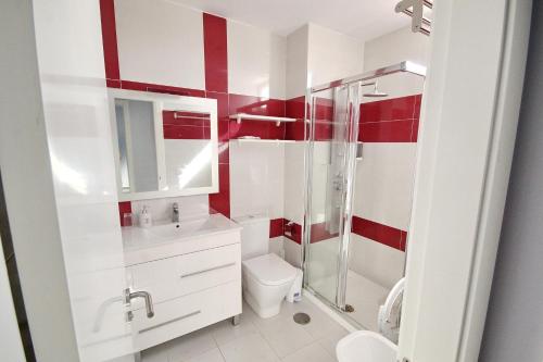 プラヤ・デ・ラス・アメリカスにあるModern sea view apartment near Playa Las Américas beachの赤と白のバスルーム(トイレ、シャワー付)