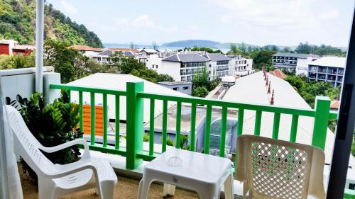 balcón con 2 sillas, mesa y vistas en Ben's House, en Ao Nang Beach