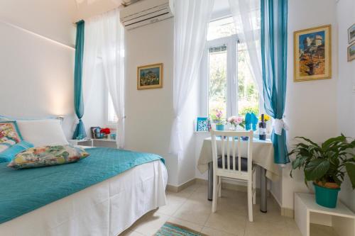um quarto com uma cama, uma mesa e uma janela em Studio Elly em Dubrovnik