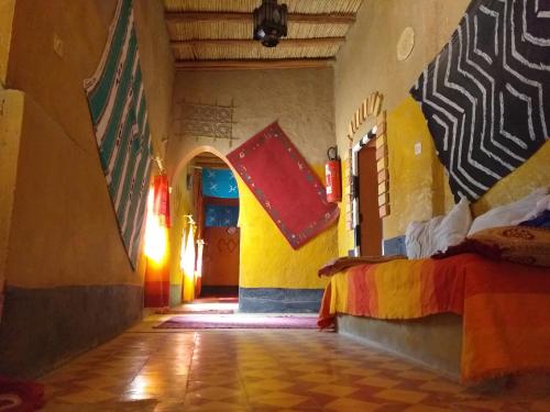 a room with a bed and flags on the wall at Auberge Camping Ocean des dunes in Merzouga