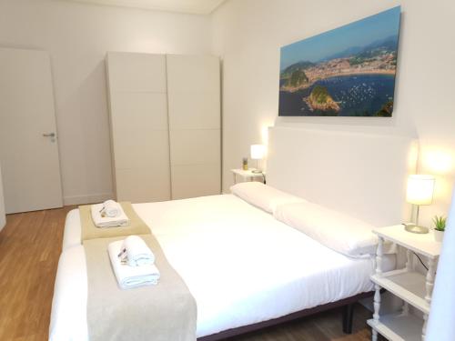 a white room with two beds with towels on them at URBIETA CENTRO in Donostia-San Sebastián
