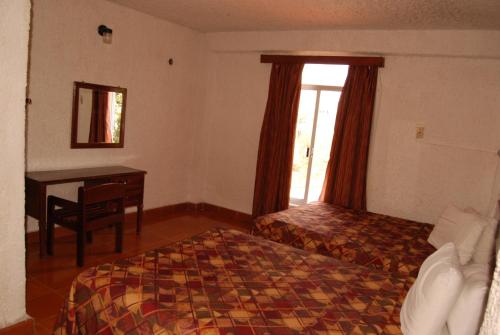 a bedroom with a bed and a desk and a window at Hotel Tankah Cancun in Cancún