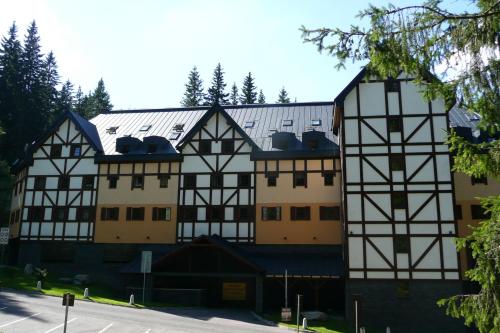 a large building with black and white facades at Apartmány Pod Javorem in Pec pod Sněžkou