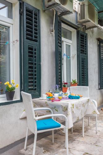 ein Tisch mit zwei Stühlen und ein Tisch mit Blumen in der Unterkunft Studio Elly in Dubrovnik