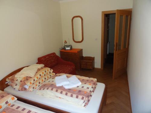 a bedroom with two beds and a chair and a mirror at Apartmány Pod Javorem in Pec pod Sněžkou