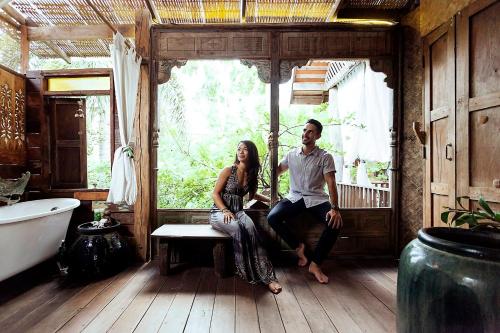 a man and a woman sitting on a bench in a bathroom at BaanBooLoo Village in Chiang Mai