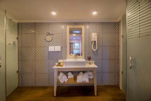 C Hotel Neve Ilan في نيفيه ايلان: حمام مع حوض ومرآة