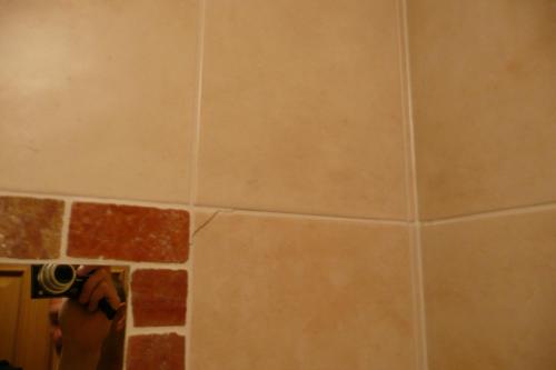 a person taking a picture of a tile wall at Apartmány Pod Javorem in Pec pod Sněžkou