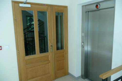 a wooden door in a room next to a elevator at Apartmány Pod Javorem in Pec pod Sněžkou