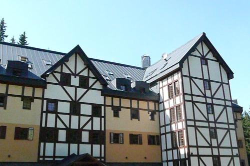 a large building with black and white at Apartmány Pod Javorem in Pec pod Sněžkou