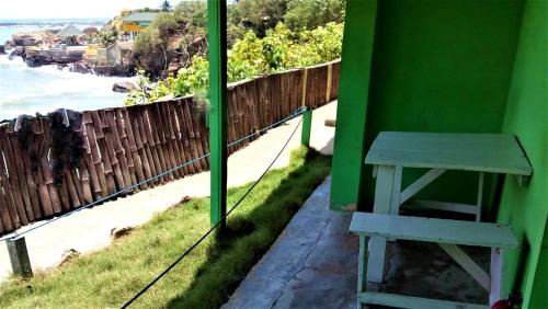 a bench on a balcony with a view of the beach at Rising Phoenix in Accra