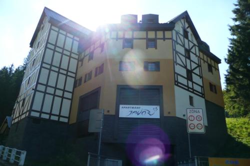a building with a sign on the side of it at Apartmány Pod Javorem in Pec pod Sněžkou