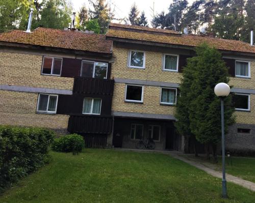 a large brick house with a tree in front of it at Apartamentai - Gintaro Įlanka in Juodkrantė
