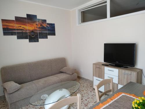 a living room with a couch and a flat screen tv at Aspra al delfino blu in Bagheria