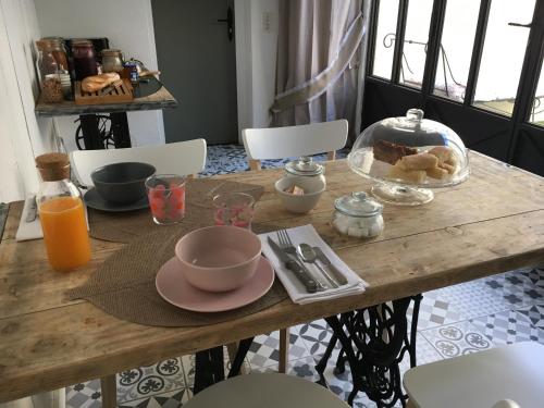 a wooden table with a plate of food on it at Ô 36 Rempart Sud B&B in Aigues-Mortes