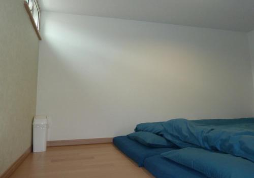 a bedroom with a bed with a blue blanket at Kanaloa Funabashi in Funabashi