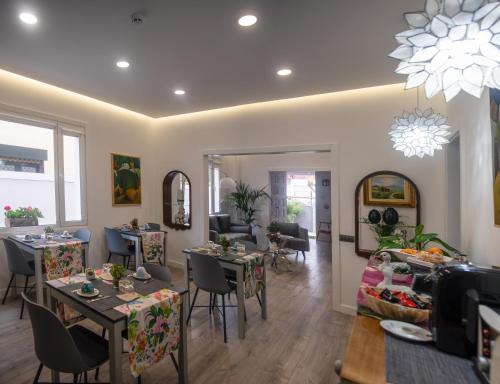 a dining room with tables and chairs and a living room at La Palmera Hotel Boutique in Las Palmas de Gran Canaria