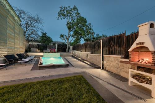 a backyard with a swimming pool and a fireplace at Villa Patrick-Luxury stone house in the center of Istria in Pazin