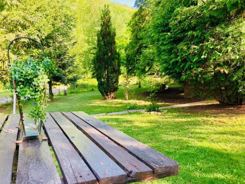 a wooden bench sitting in the grass in a park at Villa ORKA Pelister - Forest Zone in Bitola