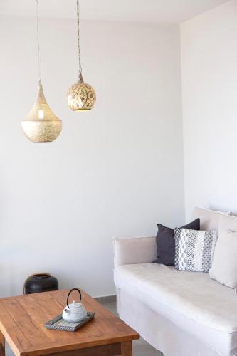a living room with a white couch and a wooden table at Anemos Luxury Villas in Vasiliki