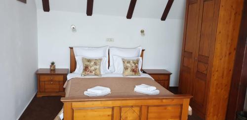 a bedroom with a bed with two night stands and two towels at Pensiunea Morii in Cristian