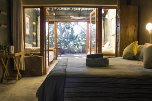 a bedroom with a large bed with a large window at The Prawn Hatchery Pty Ltd on Amatikulu in Dokodweni