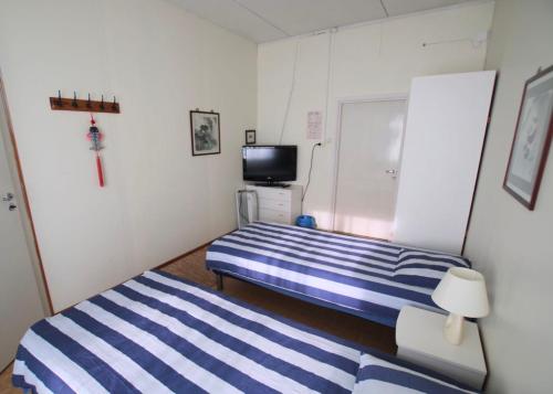 a small bedroom with two beds and a television at Käyrämön Keidas in Tiainen