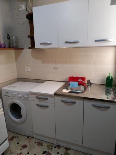a kitchen with a sink and a washing machine at Aspra al delfino blu in Bagheria