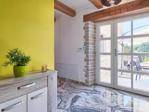 a kitchen with yellow walls and a sliding glass door at Villa Patrick-Luxury stone house in the center of Istria in Pazin