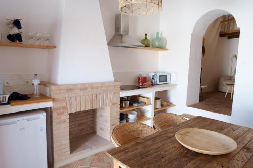 a kitchen with a brick fireplace and a wooden table at Casas de Mértola 33 in Mértola