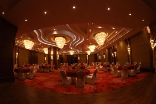 a banquet hall with tables and chairs and chandeliers at Regenta Central RS Chennai OMR SIPCOT in Chennai