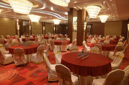 a banquet hall with red and white tables and chairs at Regenta Central RS Chennai OMR SIPCOT in Chennai