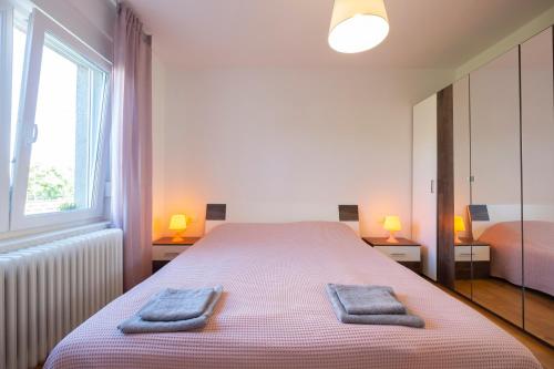 a bedroom with a large bed with two towels on it at Apartment Ksenija in Ljubljana