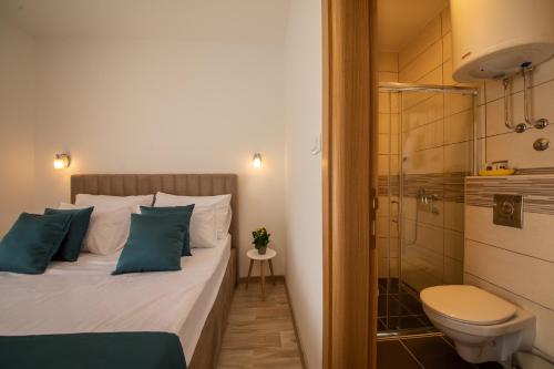 een slaapkamer met een bed, een douche en een toilet bij Apartments Vojislav in Virpazar
