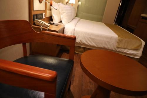 a hotel room with a bed and a desk with a phone at Regenta Central RS Chennai OMR SIPCOT in Chennai