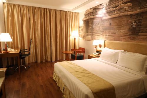 a hotel room with a bed and a stone wall at Regenta Central RS Chennai OMR SIPCOT in Chennai