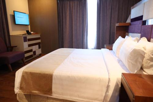 a hotel room with a large bed and a television at Regenta Central RS Chennai OMR SIPCOT in Chennai