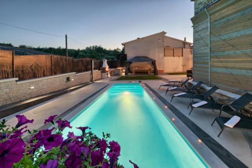 a swimming pool with chairs and a gazebo at Villa Patrick-Luxury stone house in the center of Istria in Pazin
