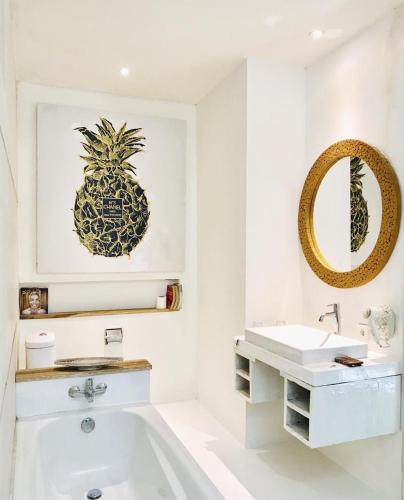 a bathroom with a pineapple picture and a sink at La Belle Villa in Seminyak