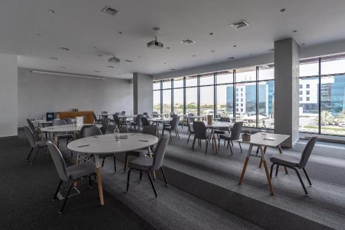 a dining room with tables and chairs and windows at Studio One Hotel in Dubai