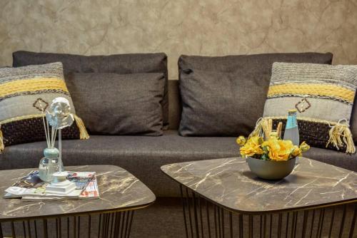 a couch with pillows and a bowl of flowers on a table at Havatselet 19 By Isrentals in Jerusalem
