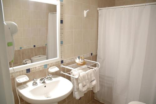 a bathroom with a sink and a shower curtain at La Barraca Resort in Merlo