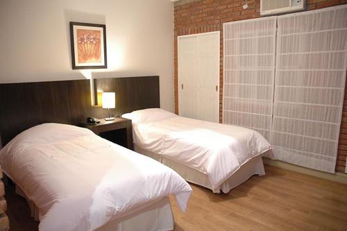 メルロにあるLa Barraca Resortのベッド2台とランプが備わったホテルの部屋